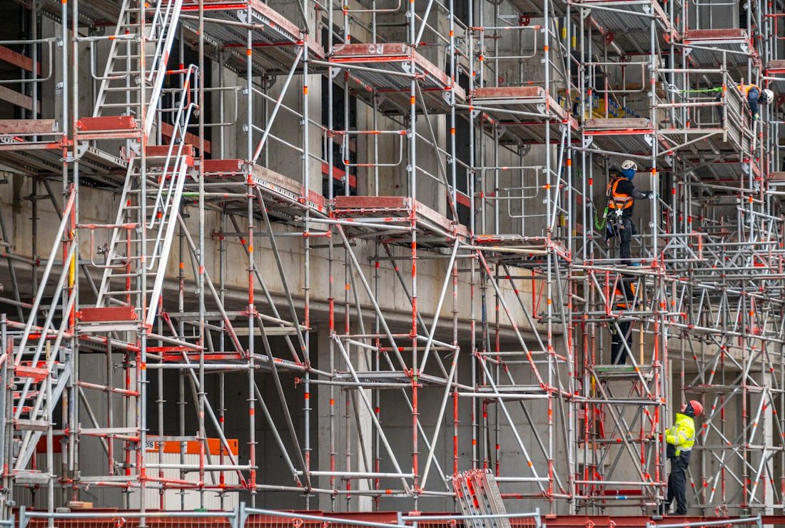 Handwerker auf einem Geruest vor einer Hausfassade